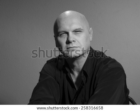 Studio black and white portrait caucasian bald men. Emotions. Squinting