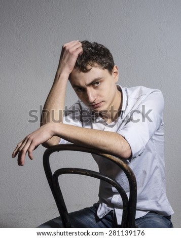 young man in a light shirt with open collar. tired
