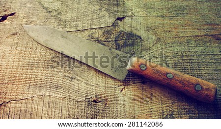 Old rusty knife on old wooden table background. Old style photo