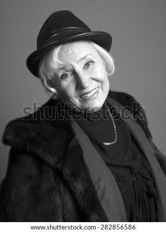 Portrait of elegant senior woman in the hat and fur coat