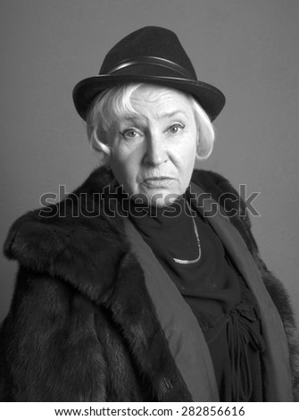 Portrait of elegant senior woman in the hat and fur coat
