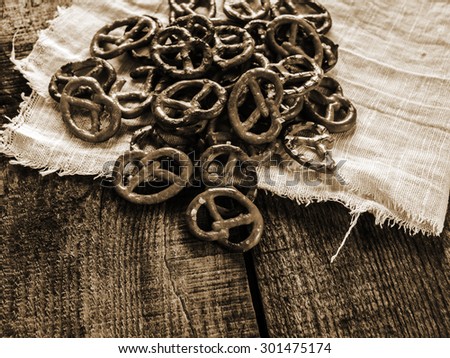 Heap of fresh Wheat salt pretzels on hessian linen fabric cloth and wooden table