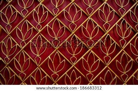 Golden curved steel door, lotus pattern, with red background in Thai temple