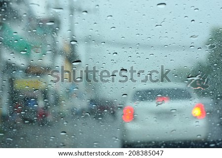 Driving in rain, Road view through car window with rain drops.