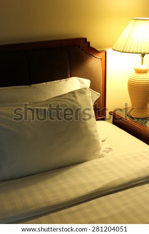 Night scene image of comfortable pillows and bed, Hotel room Interior.