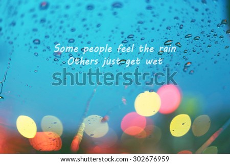 Inspirational Typographic Quote - Some people feel the rain, others just get wet. Raindrop and heart with light bokeh, rainy season background.