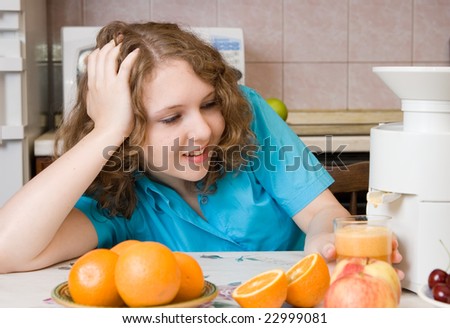 Smiling girl with blender and fruits on home kitchen