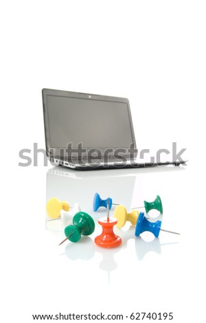 Several many-coloured thumbtacks and laptop over white background
