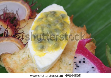 Passion fruit mousse on cocos bread, with exotic fruits on banana leaf
