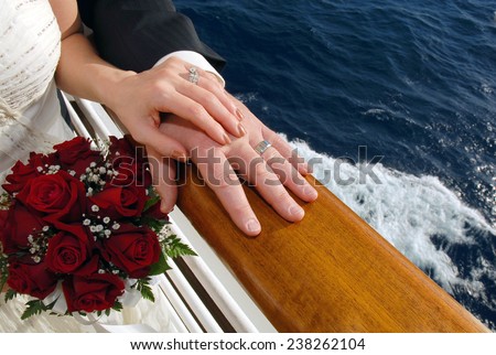 Wedding couple holding hands on a deck rail