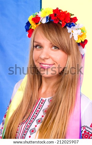 Happy cute girl in the Ukrainian national costume and Ukrainian flag