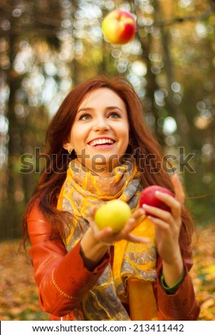 Happy Smiling Young Woman Juggling Apple in the park