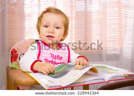 laughing little girl with book at  room