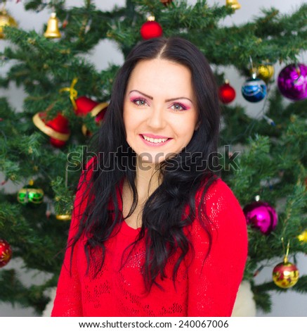 Young woman  under the Christmas tree , at room