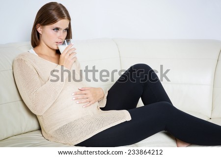 Worried pregnant woman drinking milk