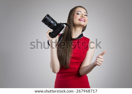 Attractive woman with full frame photo camera showing ok sign