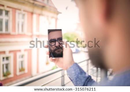 Reflection of a man\'s face in mobile phone