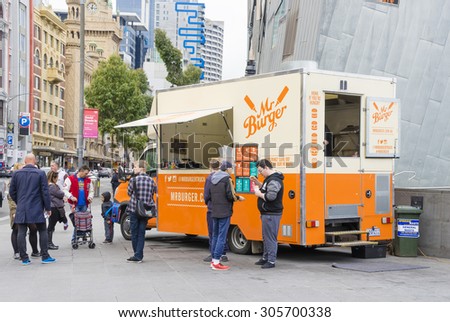 Melbourne, Australia - August 8, 2015: Food truck selling hamburgers in Melbourne street with people queuing up to buy their food. Food trucks represent a new generation of dining.
