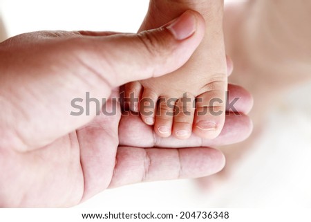 Hand of father and daughter feet