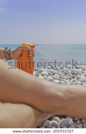 solar aerosol spraying over a leg on the beach