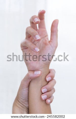 closeup of a hand of a young woman holding an arm, care for beautiful hands  - focus on the little finger