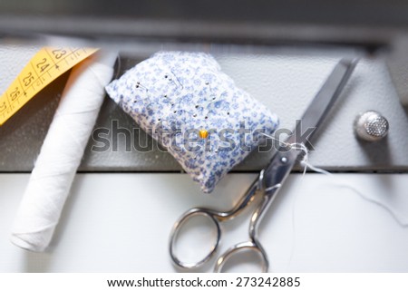 closeup of sewing accessories background - useful as a background - focus on the yellow sewing pin