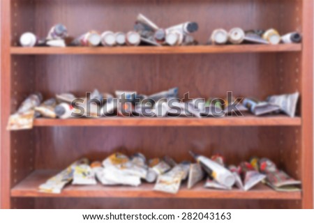unfocused paint tubes on shelves useful as a background - gaussian blur technique