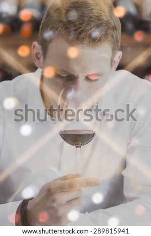 double exposure of a man on a wine tasting session is smelling the wine with the wineglass in the nose and a wine rack background