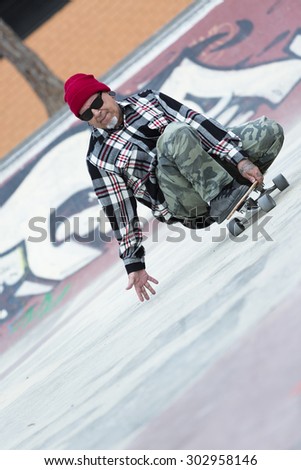 middle aged man skater skating with his skateboard on a skating park - focus on the face