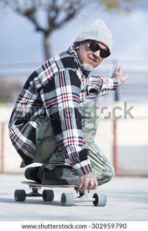 closeup of an old man skater enjoying skating with his skateboard on a skating park - focus on the face