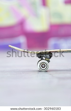 profile view of a part of a skateboard at the skate park useful as a background - focus on the wheel
