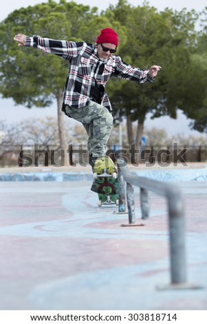 old man skater is jumping with his skateboard on a skating park - focus on the face