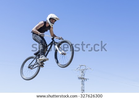 boy jumping with BMX bike on a BMX session in the mountain - focus on the leg