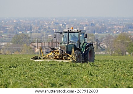 FLORENCE , ITALY - 8 April 2015 : a farmer works the land of the farm in the spring using his tractor. at this time are preparing the fields for future collections
