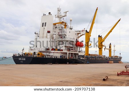 PHUKET, THAILAND - AUGUST 05 2014: Cargo ship working with crane at side Port of Phuket on August 05, 2014 in Phuket, Thailand.