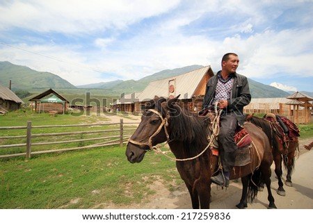 ALTAI,CHINA - JULY 21,2012 : stableman at Altai Mountains. Altai Mountains are a mountain range in East-Central Asia, where Russia, China, Mongolia and Kazakhstan come together.