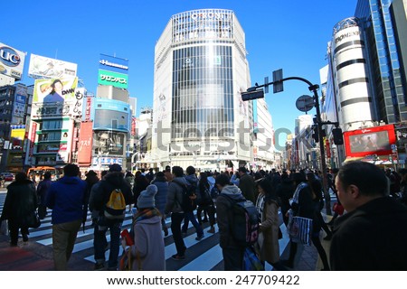 TOKYO, JAPAN - JANUARY 10,2015 : Pedestrians walk at Shibuya Crossing during the holiday season. The scramble crosswalk is one of the largest in the world.