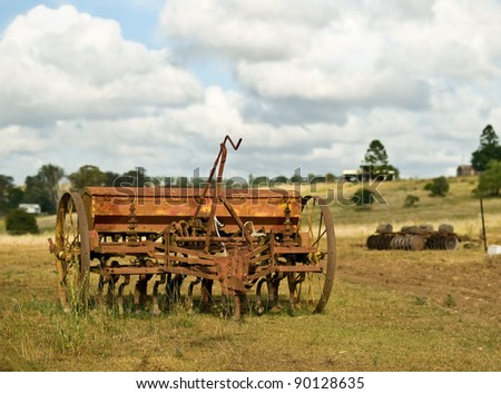 rural Australia old vintage rusty farm machinery for cultivation plough tiller with cloudy sky