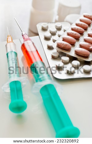 Different pills in blister and syringes with needle - health care system