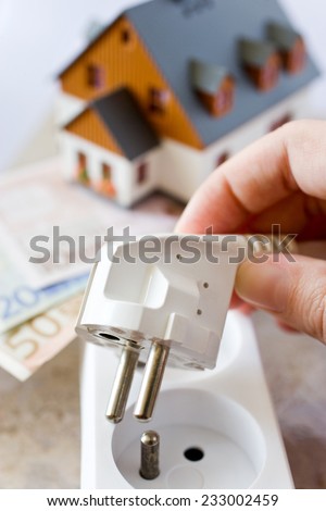 payment for electricity in model family house - energy supply and power outlet with euro money
