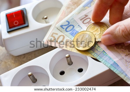 payment for electricity in model family house - energy supply and power outlet with euro money
