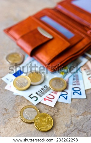 Euro money - banknotes and coins - in open brown wallet