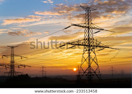 Electrical pylon and high voltage power lines near transformation station at sunset, Czech republic