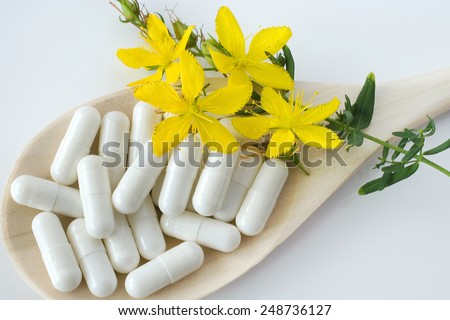 common St. John\'s wort -  hypericum perforatum - natural antidepressants - pill and yellow flowers with leaves