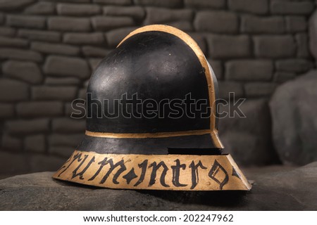 Closeup of knight armor helmet on the dark stone wall background