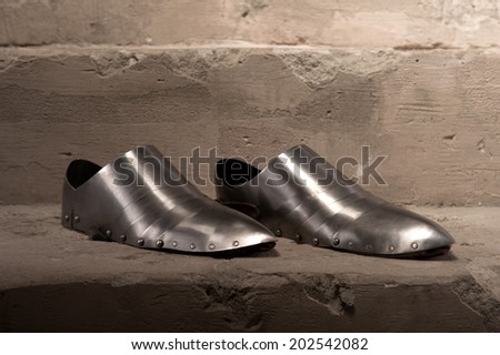 Closeup portrait of medieval armor shoes placed on stone steps