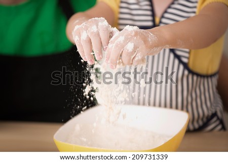 Half-length portrait of cute little daughter with happy handsome father cooking pastry, mixing flour. Eggs, bowl and roller pin