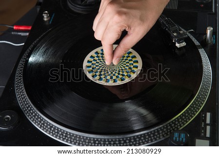 Closeup portrait of dj hands on equipment deck and mixer with vinyl record at party