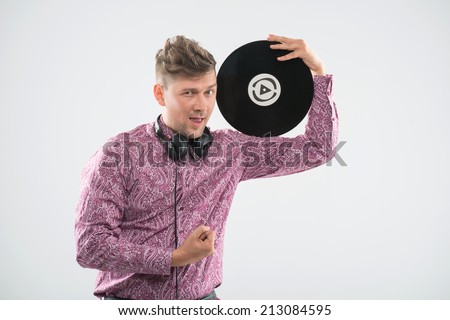 Half-length portrait of excited young DJ with stylish haircut, bow tie posing with vinyl record showing fist isolated on white background