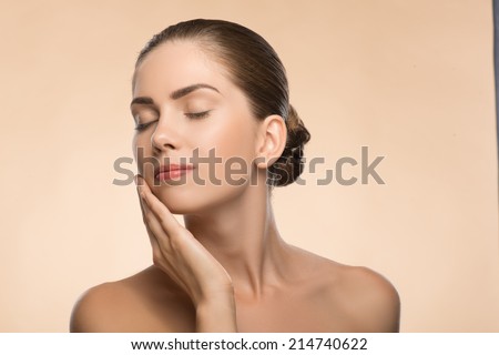 Side view Portrait of beauty face of beautiful girl with clean and  fresh skin closed eyes  touching her face isolated on beige background with copy place